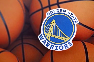 KYIV, UKRAINE - 23 Şubat 2025 Golden State Warriors basketbol takımı rozeti basketbol topu arka plan pankartıyla yatar