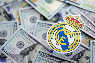 KYIV, UKRAINE - 23 Şubat 2025 Real Madrid CF futbol kulübü rozeti yüzlük banknotların üzerinde yatıyor