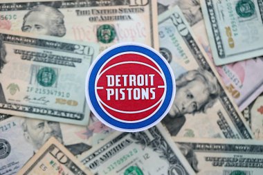 KYIV, UKRAINE - 23 Şubat 2025 Detroit Pistons basketbol takımı rozeti Amerikan dolarlarının büyük miktarına yakın.