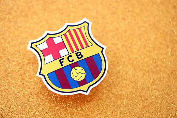 KYIV, UKRAINE - 23 Şubat 2025 FC Barcelona futbol kulübü rozeti altın sarısı parıltılı arka plan pankartıyla uzanır