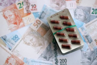 Brezilya bankaları ve ilaç hapları. Mevcut Brezilya gerçek para ve uyuşturucu banknotları büyük miktarda masada yatıyor. Brezilya 'da ilaç ve eczane kavramı