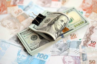 Bir sürü Amerikan doları büyük miktarda Brezilya banknotunun üzerinde yatar. Amerika 'nın parası Brezilya' nın para akışına bağlı. Brezilya 'da ekonomi ve döviz kuru kavramı