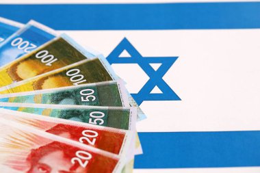 Israel New Shekels banknotları ulusal bayrak üzerinde. İsrail 'in şu anki para faturaları büyük oranda bayrağın üzerinde yatıyor. İsrail 'de iş ve yatırım kavramı
