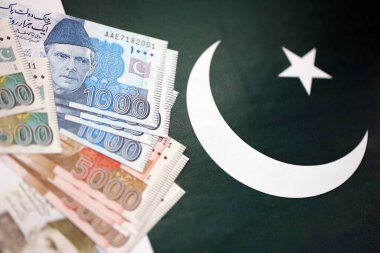Pakistan 'ın bayrak geçmişi üzerine Pakistan banknotları. Pakistan 'ın mevcut para faturaları büyük miktarlarda pankartta yatıyor. Pakistan 'da ekonomi ve ticaret kavramı