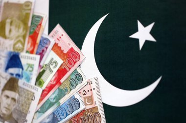 Pakistan 'ın bayrak geçmişi üzerine Pakistan banknotları. Pakistan 'ın mevcut para faturaları büyük miktarlarda pankartta yatıyor. Pakistan 'da ekonomi ve ticaret kavramı