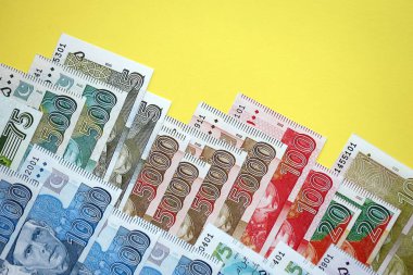 Pakistan banknotları sarı arka planda. Pakistan 'ın mevcut para faturaları büyük miktarda masada yatıyor. Pakistan 'da iş ve yatırım kavramı