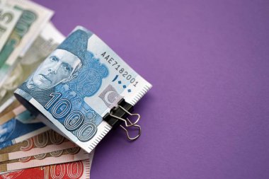 Pakistan mor arka planda banknotlar halinde. Pakistan 'ın mevcut para faturaları büyük miktarda masada yatıyor. Pakistan 'da iş ve yatırım kavramı