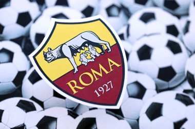 KYIV, UKRAINE - 23 Şubat 2025 Roma futbol kulübü rozeti futbol topu arkaplan pankartında yatıyor