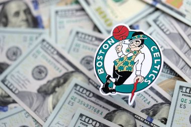 KYIV, UKRAINE - 23 Şubat 2025 Boston Celtics basketbol takımı rozeti yüzlük banknotların üzerinde.