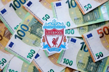 KYIV, UKRAINE - 23 Şubat 2025 Liverpool UK FC futbol kulübü rozeti büyük miktarda EURO para banknotları üzerine kuruludur