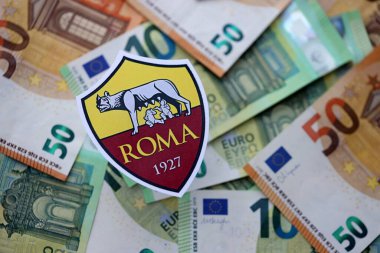 KYIV, UKRAINE - 23 Şubat 2025 Roman futbol kulübü rozeti büyük miktarda EURO para banknotlarının üzerinde yatıyor