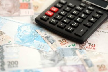 Brezilya banknotları ve hesap makinesi. Mevcut Brezilya gerçek para ve hesap makinesi büyük miktarda masada yatıyor. Brezilya 'da vergilendirme ve para konsepti