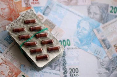 Brezilya bankaları ve ilaç hapları. Mevcut Brezilya gerçek para ve uyuşturucu banknotları büyük miktarda masada yatıyor. Brezilya 'da ilaç ve eczane kavramı