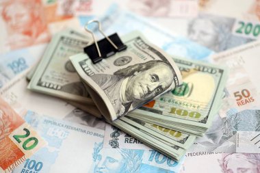 Bir sürü Amerikan doları büyük miktarda Brezilya banknotunun üzerinde yatar. Amerika 'nın parası Brezilya' nın para akışına bağlı. Brezilya 'da ekonomi ve döviz kuru kavramı
