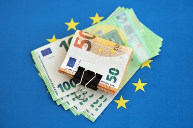 Avrupa sendikasının mavi bayrağına bir deste avroluk banknot yakın. Avrupa 'da iş ve ekonomi kavramı