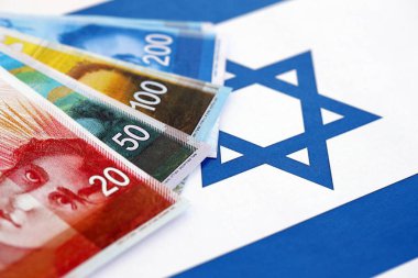 Israel New Shekels banknotları ulusal bayrak üzerinde. İsrail 'in şu anki para faturaları büyük oranda bayrağın üzerinde yatıyor. İsrail 'de iş ve yatırım kavramı
