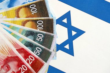 Israel New Shekels banknotları ulusal bayrak üzerinde. İsrail 'in şu anki para faturaları büyük oranda bayrağın üzerinde yatıyor. İsrail 'de iş ve yatırım kavramı