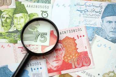 Pakistan banknotları ve büyüteç. Pakistan 'ın mevcut para ve büyüteç faturaları büyük miktarda masanın üzerinde duruyor. Pakistan 'da mali izleme ve vergilendirme kavramı