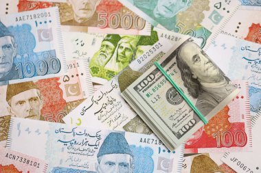 Bir sürü Amerikan doları Pakistan Rupileri 'nin banknotlarına yakın duruyor. Amerikan para demeti Pakistan 'ın para banknotlarında yatıyor. Pakistan 'da ekonomi ve döviz kuru kavramı