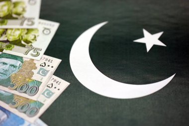 Pakistan 'ın bayrak geçmişi üzerine Pakistan banknotları. Pakistan 'ın mevcut para faturaları büyük miktarlarda pankartta yatıyor. Pakistan 'da ekonomi ve ticaret kavramı
