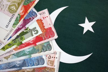Pakistan 'ın bayrak geçmişi üzerine Pakistan banknotları. Pakistan 'ın mevcut para faturaları büyük miktarlarda pankartta yatıyor. Pakistan 'da ekonomi ve ticaret kavramı