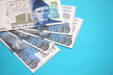 Pakistan banknotları mavi arka planda. Pakistan 'ın mevcut para faturaları büyük miktarda masada yatıyor. Pakistan 'da iş ve yatırım kavramı