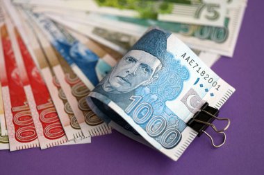 Pakistan mor arka planda banknotlar halinde. Pakistan 'ın mevcut para faturaları büyük miktarda masada yatıyor. Pakistan 'da iş ve yatırım kavramı