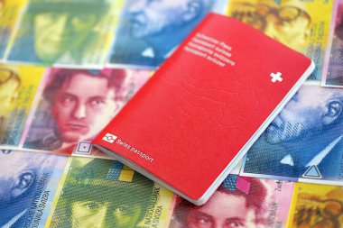 İsviçre frangı banknotları ve pasaportu. Mevcut banknotlar ve biyometrik geçiş kartları masanın üzerinde. İsviçre 'de seyahat ve tatil kavramı