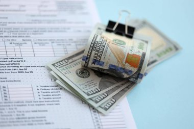 Masada 1040 bireysel gelir vergisi iadesi formuyla birlikte büyük miktarda Amerikan dolarları var. ABD 'de vergilendirme ve muhasebe kavramı