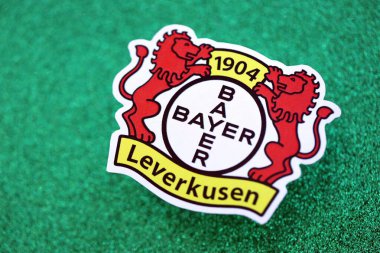 KYIV, UKRAINE - 23 Şubat 2025 Bayer 04 Leverkusen futbol kulübü rozeti zümrüt yeşili simli arka plan pankartıyla uzanır