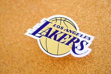 KYIV, UKRAINE - 23 Şubat 2025 Los Angeles Lakers basketbol takımı rozeti altın sarısı parıltılı arka plan pankartıyla uzanır