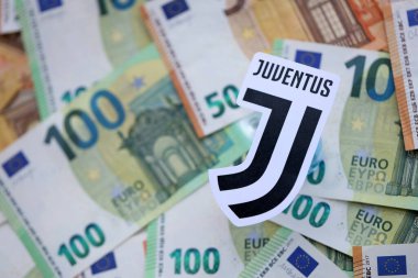 KYIV, UKRAINE - 23 Şubat 2025 Juventus FC futbol kulübü rozeti büyük miktarda EURO para banknotlarının üzerinde yatıyor