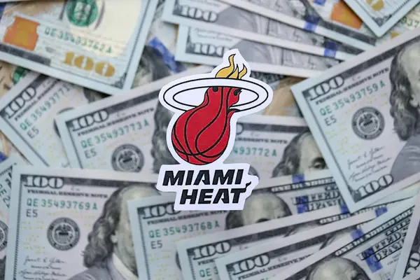 KYIV, UKRAINE - 23 Şubat 2025 Miami Heat basketbol takımı rozeti yüzlük banknotların üzerinde.