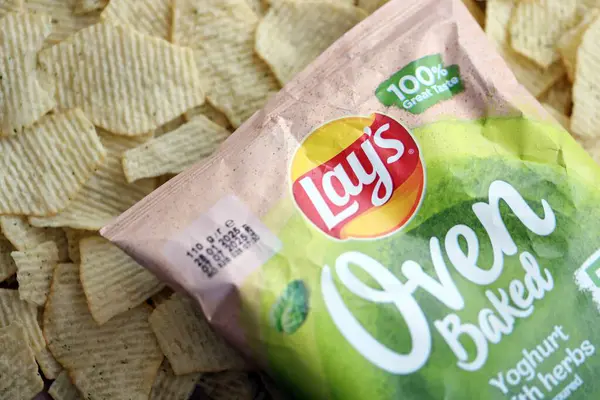 KYIV, UKRAINE - 19 Nisan 2025 Fırında fırında yoğurt ve yeşil patates cipsi ve Lays resmi logosu.