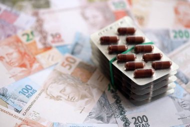 Brezilya bankaları ve ilaç hapları. Mevcut Brezilya gerçek para ve uyuşturucu banknotları büyük miktarda masada yatıyor. Brezilya 'da ilaç ve eczane kavramı