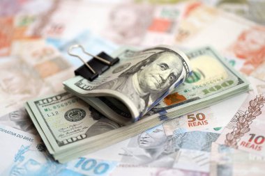 Bir sürü Amerikan doları büyük miktarda Brezilya banknotunun üzerinde yatar. Amerika 'nın parası Brezilya' nın para akışına bağlı. Brezilya 'da ekonomi ve döviz kuru kavramı