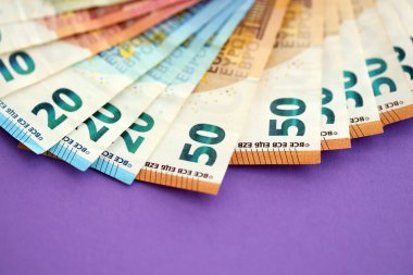 Avrupa para birimi banknotlarının büyük bir kısmı mor renkli masaya yakın. Avrupa 'da iş ve gelir kavramı