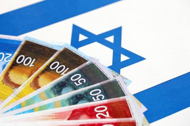 Israel New Shekels banknotları ulusal bayrak üzerinde. İsrail 'in şu anki para faturaları büyük oranda bayrağın üzerinde yatıyor. İsrail 'de iş ve yatırım kavramı