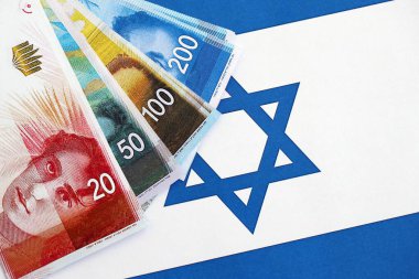 Israel New Shekels banknotları ulusal bayrak üzerinde. İsrail 'in şu anki para faturaları büyük oranda bayrağın üzerinde yatıyor. İsrail 'de iş ve yatırım kavramı
