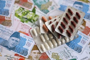 Pakistan banknotları ve ilaç hapları. Pakistan 'ın mevcut para ve uyuşturucu faturaları büyük miktarda masada yatıyor. Pakistan 'da ilaç ve eczane kavramı
