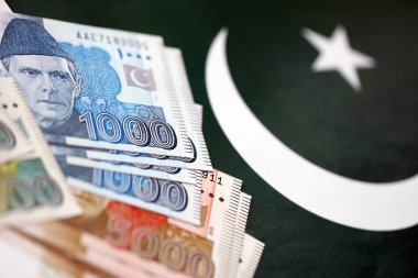 Pakistan 'ın bayrak geçmişi üzerine Pakistan banknotları. Pakistan 'ın mevcut para faturaları büyük miktarlarda pankartta yatıyor. Pakistan 'da ekonomi ve ticaret kavramı