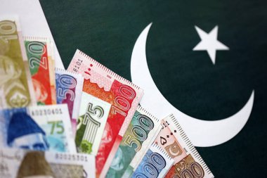 Pakistan 'ın bayrak geçmişi üzerine Pakistan banknotları. Pakistan 'ın mevcut para faturaları büyük miktarlarda pankartta yatıyor. Pakistan 'da ekonomi ve ticaret kavramı