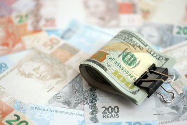 Bir sürü Amerikan doları büyük miktarda Brezilya banknotunun üzerinde yatar. Amerika 'nın parası Brezilya' nın para akışına bağlı. Brezilya 'da ekonomi ve döviz kuru kavramı