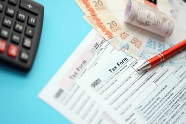 Brezilya banknotları, hesap makinesi ve vergi formlarıyla. Şu anki Brezilya gerçek para ve vergi borçları yakın plan. Brezilya 'da vergi ödeme ve muhasebe kavramı