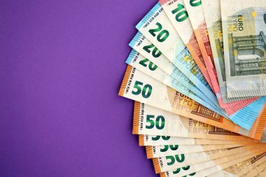 Avrupa para birimi banknotlarının büyük bir kısmı mor renkli masaya yakın. Avrupa 'da iş ve gelir kavramı