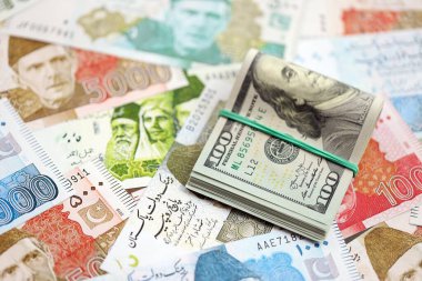Bir sürü Amerikan doları Pakistan Rupileri 'nin banknotlarına yakın duruyor. Amerikan para demeti Pakistan 'ın para banknotlarında yatıyor. Pakistan 'da ekonomi ve döviz kuru kavramı