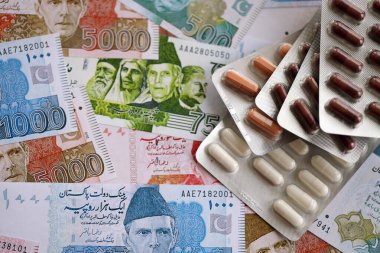Pakistan banknotları ve ilaç hapları. Pakistan 'ın mevcut para ve uyuşturucu faturaları büyük miktarda masada yatıyor. Pakistan 'da ilaç ve eczane kavramı