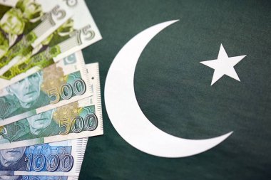 Pakistan 'ın bayrak geçmişi üzerine Pakistan banknotları. Pakistan 'ın mevcut para faturaları büyük miktarlarda pankartta yatıyor. Pakistan 'da ekonomi ve ticaret kavramı