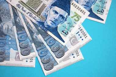 Pakistan banknotları mavi arka planda. Pakistan 'ın mevcut para faturaları büyük miktarda masada yatıyor. Pakistan 'da iş ve yatırım kavramı