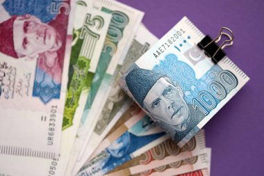 Pakistan mor arka planda banknotlar halinde. Pakistan 'ın mevcut para faturaları büyük miktarda masada yatıyor. Pakistan 'da iş ve yatırım kavramı